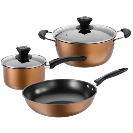 A three-piece premium non-stick cookware set, including a large skillet, a medium saucepan with lid, and a small saucepan with lid, all three with bronze-colored exteriors and black interiors, displayed on a wooden surface.